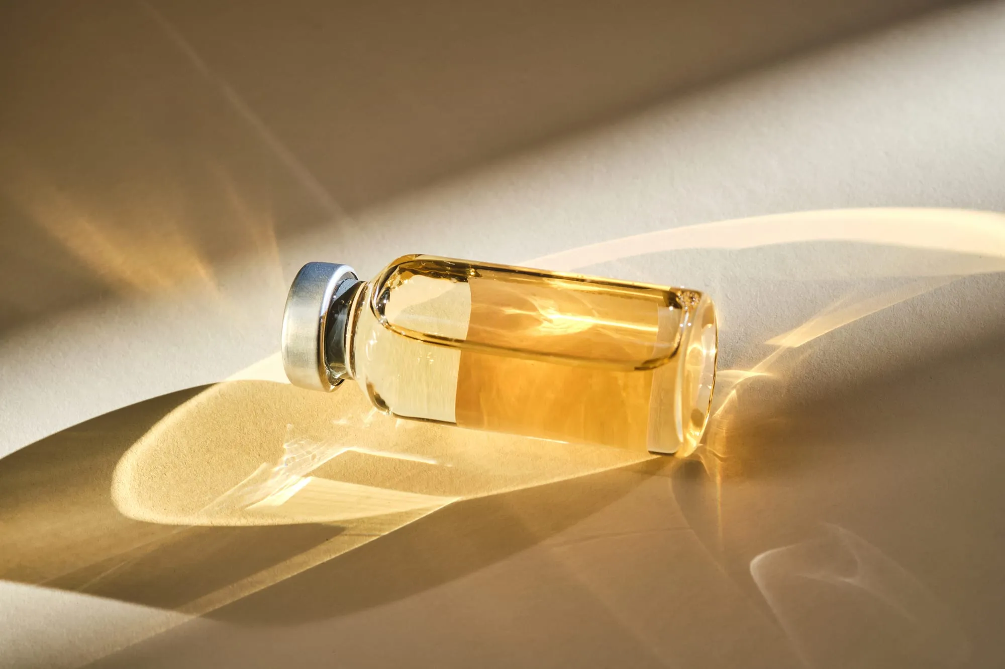 A small glass vial resting in warm, low sunlight.